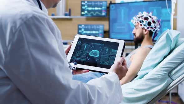 Doctor Holding Tablet with Brain Analysis in Modern Facility for Health Research alt