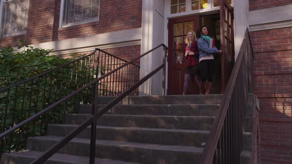 Two college students on campus walking down stairs