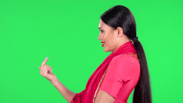 Portrait of a Young Indian Girl in National Classic Red Sari Is Looking Straight and Coquettishly alt