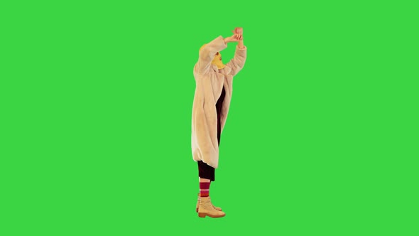 Young Girl in Balaclava Making Some Energetic Hand Gestures on a Green Screen Chroma Key alt