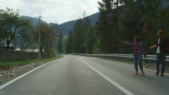 Happy Tourists Hitchhiking Car on Highway alt