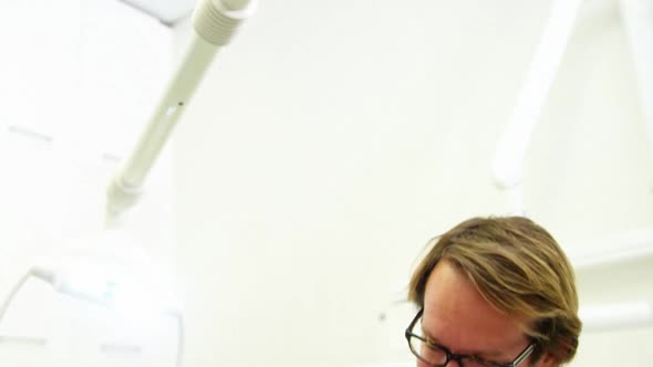Dentist examining a young patient with dental tools alt