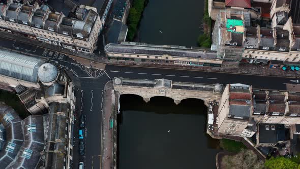 Cinematic dolly back pan up drone shot of Pulteney bridge central Bath UK alt
