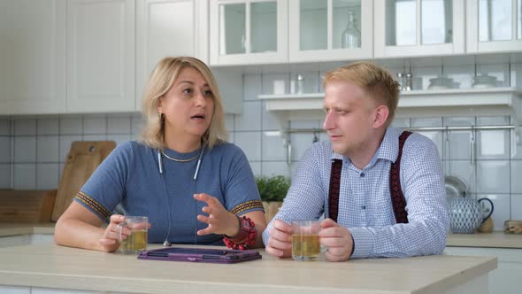 Mature Mother Chatting with Adult Son in Kitchen alt