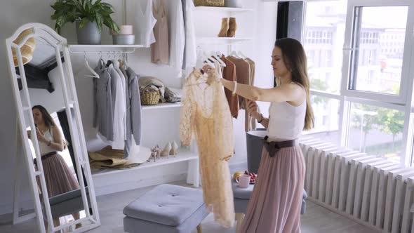 Woman Trying Elegant Clothes in Wardrobe