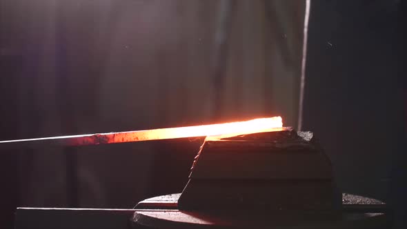 Blacksmith Using Hammer Machine for Shaping Hot Metal Blank in Forge Workshop