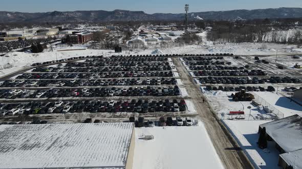 Drone view over large parking lot for industrial building on a bright sunny day in the winter.