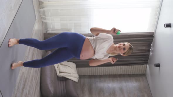 Pregnant Woman with a Big Tummy Dancing to Music in Her Living Room on a Fitness Mat Happy Pregnancy