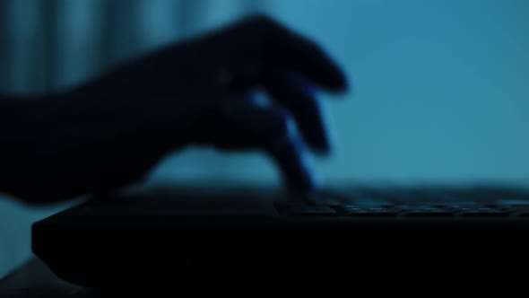 Silhouette of Male Palm Hand Typing on Laptop Keyboard