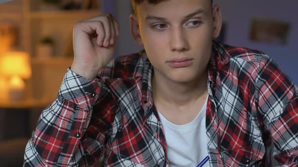 Sleepy Male Student Writing Essay, Sitting at Home Table, Boring School Subject alt