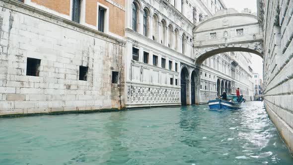 COVID-19 in Italy. Lonely Venice boat on channel with bridge of Sighs, Venice