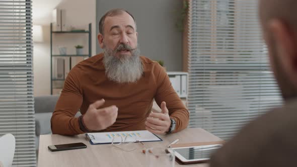 Senior Businessman Talking to Unrecognizable Colleague alt