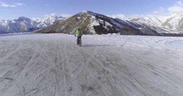 Forward Aerial Over Biker Man Cycling on Snowy Path During Winter with Mtb Ebike alt