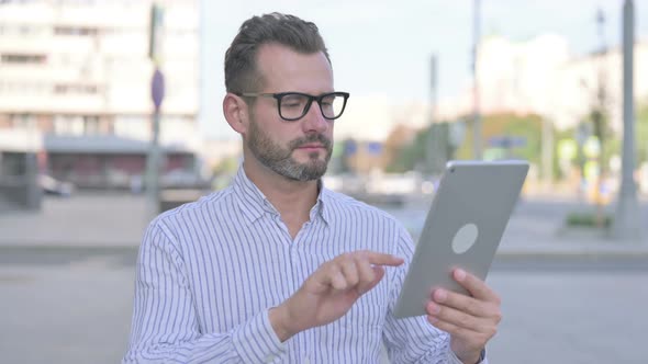 Upset Young Adult Man Reacting to Loss on Tablet Outdoor alt