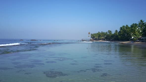 Blue Endless Ocean at Sandy Beach with High Green Palms alt