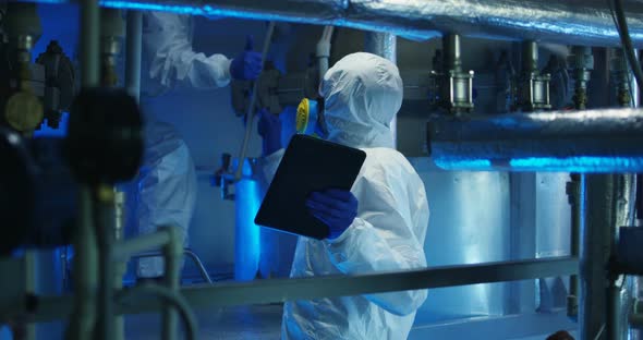 Scientists in Hazmat Suit Conducting Maintenance alt
