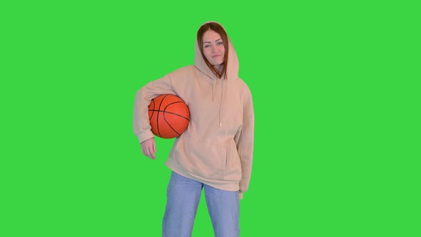 Young Girl Holding a Basketball Smiling to Camera on a Green Screen Chroma Key alt