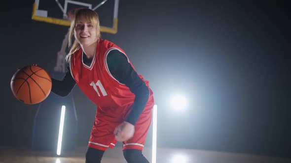 Portrait of Cheerful Sporty Female Basketball Player Hits the Ball Off the Floor and Warms Up Before alt