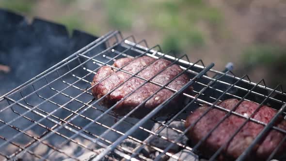 Beef Burgers Cutlets are Roasting on the Charcoal Barbecue Grill alt