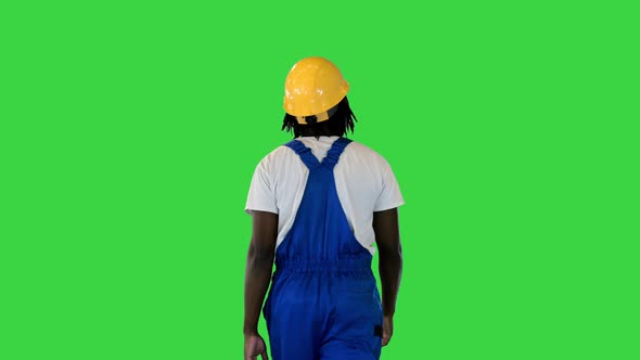 Handyman in a Helmet and Working Suit Walking on a Green Screen Chroma Key