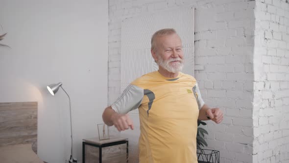 Smiling Grandfather Fan of Sports and Healthy Lifestyle Performs Useful Exercises To Maintain alt