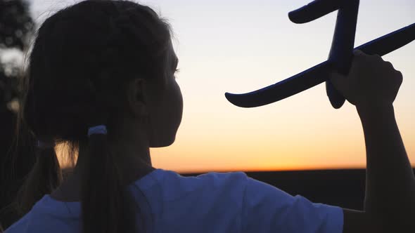 Close Up of Small Female Child Holding in Hand Toy at Dusk Time alt