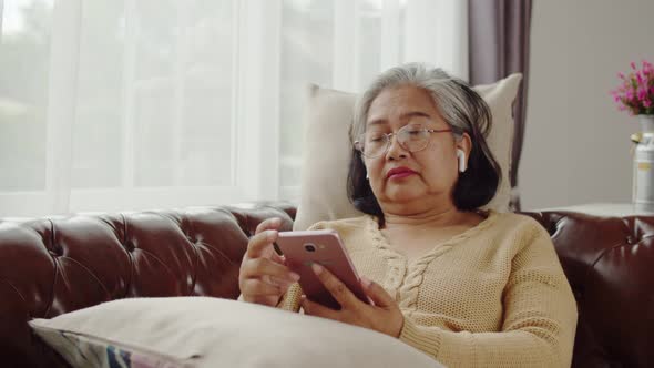 Senior woman doze asleep while listening music with smartphone alt