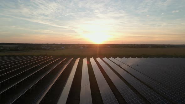 Aerial Drone View Into Large Solar Panels at a Solar Farm at Bright Sunset. Solar Cell Power Plants alt