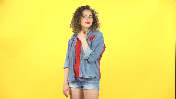 Curly Girl Coquettishly Smiles While Looking at the Camera, Builds Her Eyes, Alluringly alt