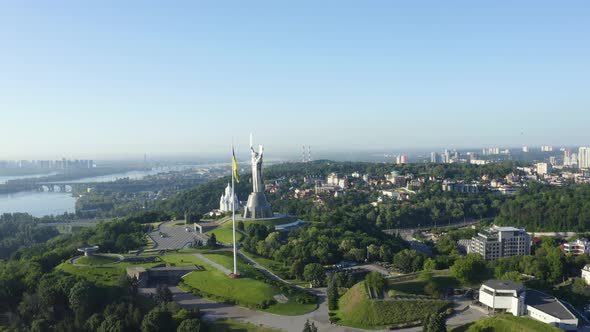 Aerial View of the Ukrainian Flag Waving in the Wind Against the City of Kyiv alt