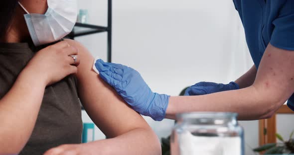 Closeup Nurse in Blue Scrubs Medical Gloves Gives Vaccine Injection Shot with Hypodermic Needle to alt