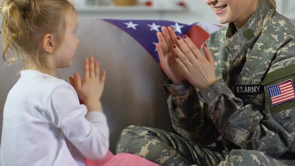Young Woman in Military Uniform Playing With Daughter at Home, Family Time alt