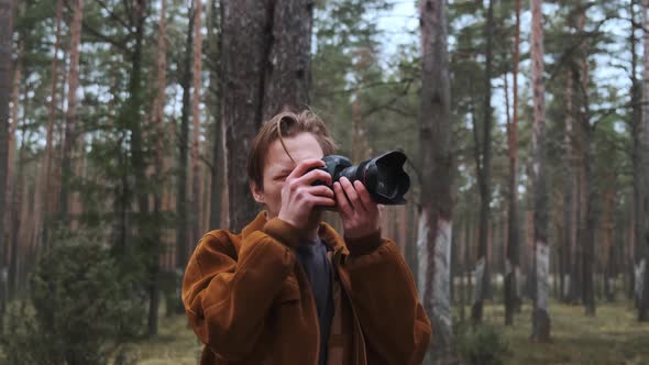 A Photographer Takes Pictures in the Woods a Young Man Takes Pictures in the Woods with His Camera alt