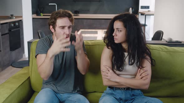 Couple Quarrelling Sitting on Sofa at Home. Husband Yells at His Wife, Family Conflict. Relationship alt