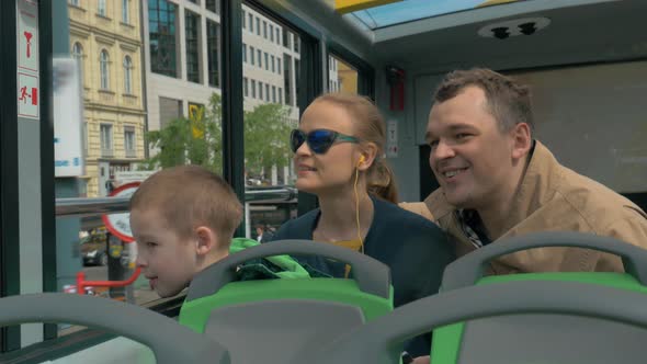 Family with child traveling around Vienna by double-decker bus alt