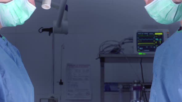 Tilt Up Shot of Female Surgeons in Medical Uniform Using Professional Tools While Standing Under alt
