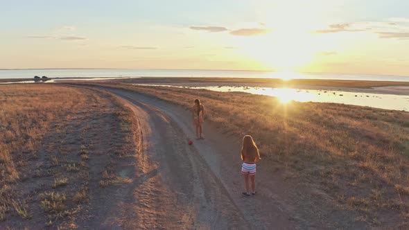 Two Sisters Play on Wild Sandy Terrain alt