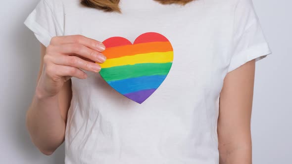 Woman or Girl in White Tshirt Holding Heat Painted in Colors of Gay Pride Flag Colorful Symbol of
