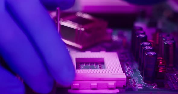 Closeup of Installing Computer Processor Assembling Motherboard Fixing Details in Protective Blue alt