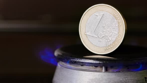 Gas Stove Burner with One Euro Coin Standing Vertically on Top Burning Gas