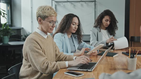 Business Woman Working on Laptop with Colleagues Sitting at Table alt