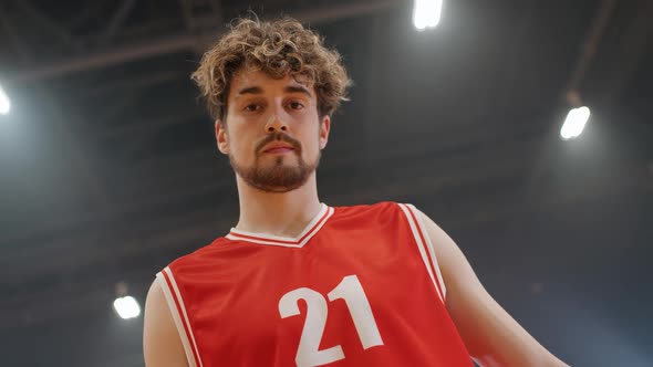 Portrait of an Caucasian Man Basketball Player Serious Looking at the Camera and Holds the Ball in alt