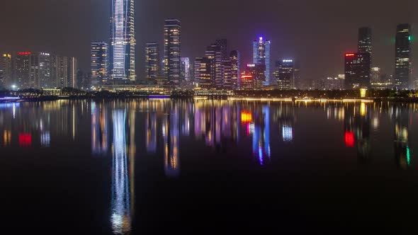 Shenzhen Urban Cityscape China Timelapse at Night with Reflection in Water Pan Up alt