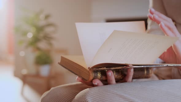 Woman Reads Book at Home. Hand Turning Pages of a Book