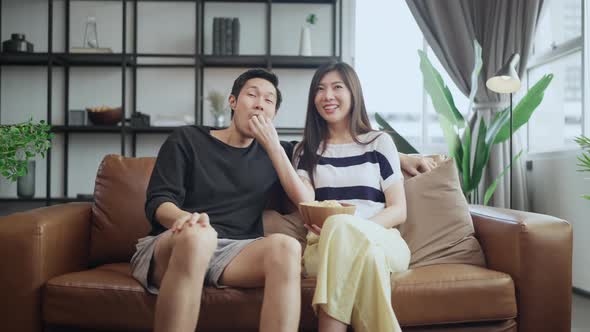 asian adult lover marry couple enjoy  watching tv on sofa couch together alt