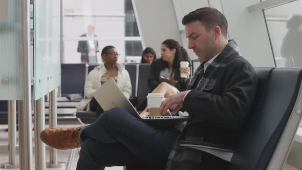 Businessman working on laptop at airport