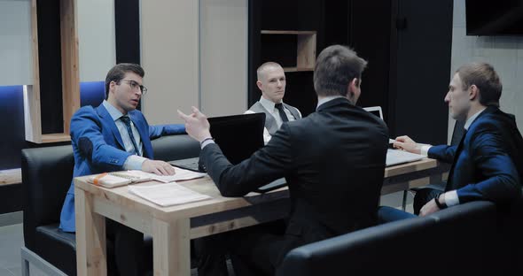 Young Men at a Meeting in a Modern Office Discussing the Company's Plans