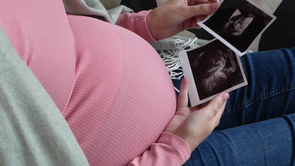 A woman expecting the birth of her baby looks at a picture. Pregnancy and childbirth.