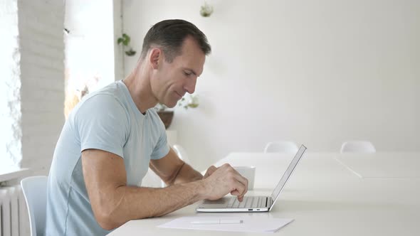Man Typing On Laptop in Office alt
