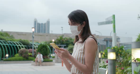 Woman wear face mask and use of mobile phone at outdoor